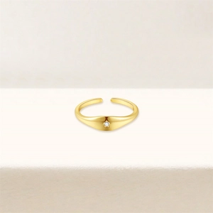 Detail of gold-plated wavy toe ring featuring an eight-pointed star and zircon stone