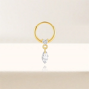Macro-opname van gouden oorring met hartsteen en marquise zirkoon druppel hanger