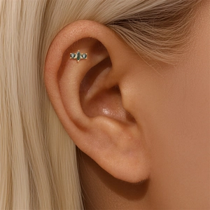 Close-up of gold helix stud with marquise-cut green moss agate on model's ear