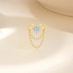 Dettaglio ear cuff floreale dorato con opale blu e catenelle pendenti in zircone