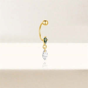 Macro shot of gold kite-cut green stone and marquise-cut crystal piercing jewelry