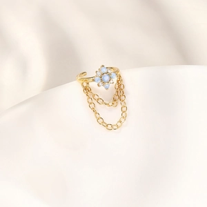Dettaglio di ear cuff in argento s925 con fiore di opale blu e catene a nappe d'oro