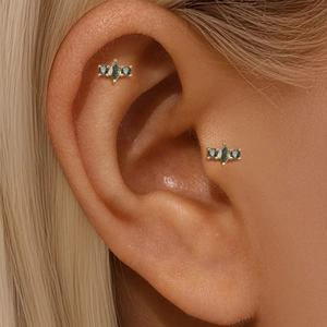 Close-up of three-stone gold ear stud featuring marquise green moss agate on ear