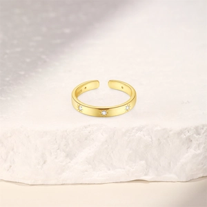 Detail of S925 silver wave ring with gold finish and three zircon star engravings