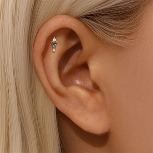 Macro detail of moss agate ear stud with white zircons on a model's ear cartilage