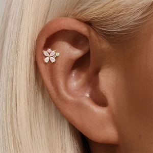 Detailed close-up of a golden butterfly helix piercing with pink marquise stones