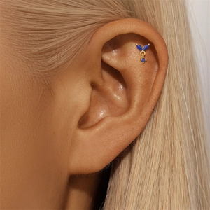 Detail of s925 gold ear bone stud featuring navy lapis lazuli clover leaf design