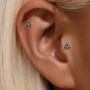Detailopname van s925 zilveren regenboogsteen oorsteker op helix en tragus piercing