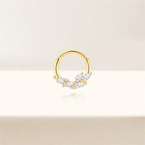 Macro-opname van gouden piercingring met marquise witte zirkoon en paarse steen