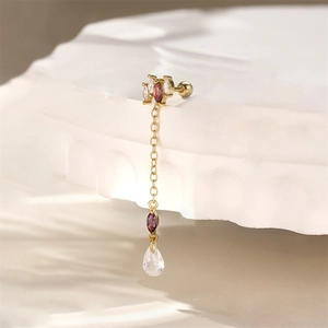 Macro detail of gold marquise amethyst cartilage earring with chain and drop charm