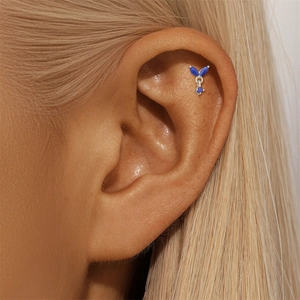 Close-up of S925 silver ear stud with deep blue lapis lazuli stones on model's ear