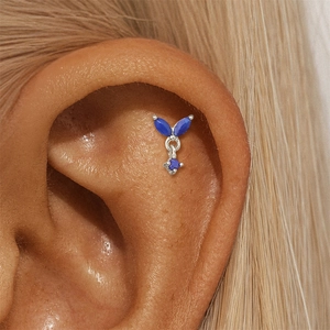 Close-up of S925 silver ear piercing with blue lapis lazuli stones on a model ear