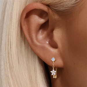 Close-up of s925 silver flower drop earring with moonstone and blue gemstone detail
