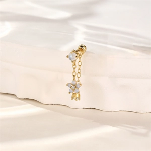 Detailed macro of gold flower cartilage stud with chains and opal stones on marble