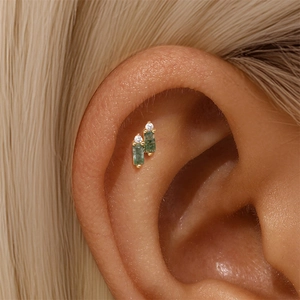 Detail of s925 gold ear bone studs featuring green moss agate and round white zircon