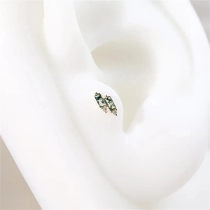 Macro shot of s925 gold moss agate earrings with rectangle stones and zircons on ear model