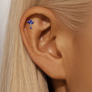 Macro detail of S925 silver helix piercing with royal blue lapis lazuli on model ear