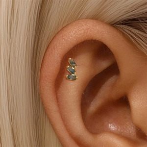 Macro detail of three rectangular green moss agate stones on a gold ear stud