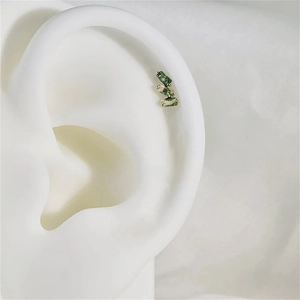 Macro detail of moss agate stud earrings with three rectangular green stones on model