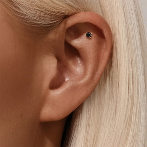 Macro shot of s925 silver black gemstone stud earring on ear cartilage