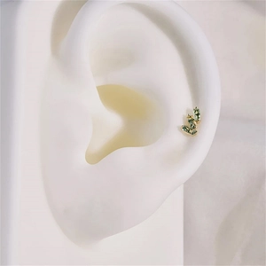 Detail of s925 gold ear stud with three green baguette-cut moss agate stones on ear model