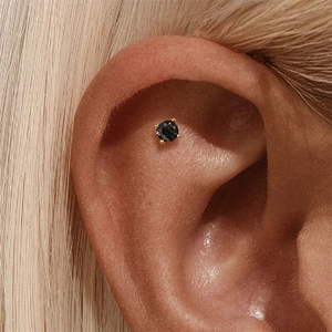Macro view of gold s925 silver stud earring with round rutilated black quartz inlay