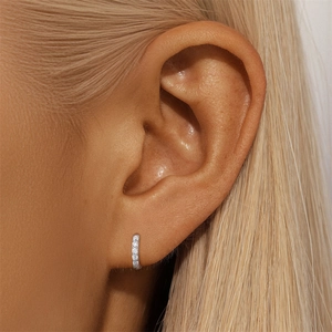 Detail von S925 Sterling Silber Huggie Ohrringen mit Zirkonia-Besatz getragen am Model