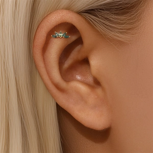 Macro shot of s925 gold piercing stud with five marquise-cut green moss agate stones