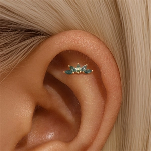 Close-up of moss agate ear stud in crown shape with green marquise stones