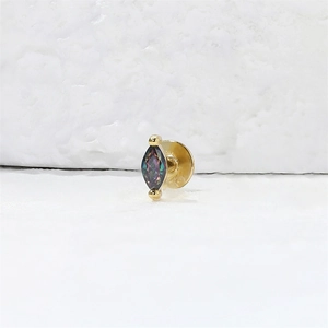 Macro-opname van een marquise-geslepen regenboogsteen oorsteker met gouden schroefbasis