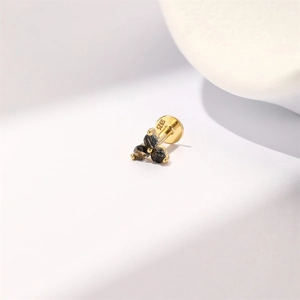 Macro shot of S925 sterling silver stamp on golden triangle ear stud with black crystals