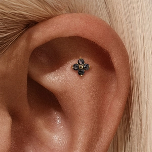 Detailed close-up of s925 silver flower stud earring with black crystals on ear
