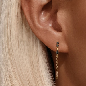 Détail du piercing d'oreille en argent s925 avec quartz noir et pampille dorée