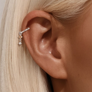 Dettaglio del ear cuff in argento S925 con gemma arancione e ciondolo a forma di stella