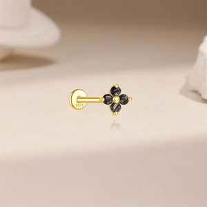 Detailed macro of S925 sterling silver stamp on golden flower stud earring with black stones