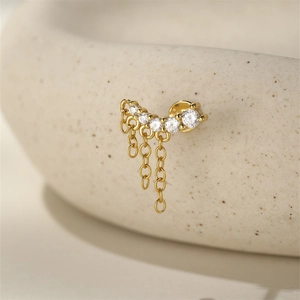Detailed close-up of golden s925 silver stud earring with crown zircon and tassel chains