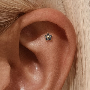 Macro shot of s925 silver flower piercing earring with black rutilated quartz on ear