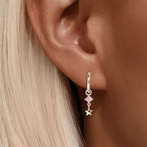 Dettaglio di orecchini a cerchio in argento S925 con zircone rosa e ciondolo a stella