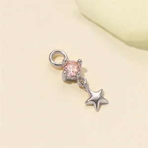 Macro di un ciondolo a stella in argento S925 con zircone rosa incastonato a griffe
