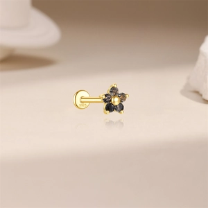 Macro detail of S925 sterling silver stamp on golden flower labret with black rutilated quartz