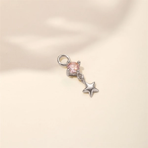 Dettaglio di un ciondolo a stella in argento con una brillante pietra di zircone rosa