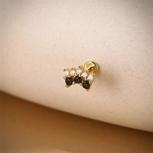 Détail du poinçon S925 sur boucle d'oreille plaquée or avec zircons noirs et blancs