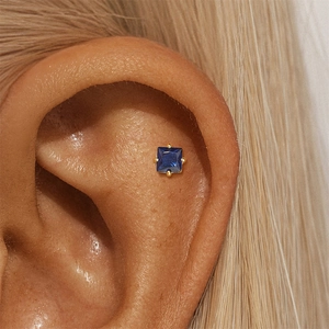 Detail of square blue zircon earring with gold plating shown on the tragus
