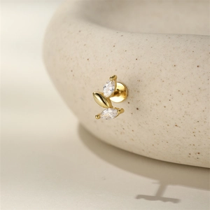 Macro shot of s925 gold leaf cartilage stud with marquise cubic zirconia on ceramic
