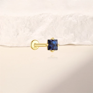 Macro shot of S925 sterling silver square blue zircon stud with four-prong gold plating
