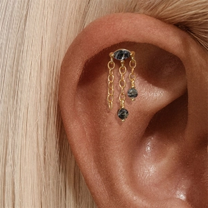 Détail du piercing d'oreille s925 argent avec quartz noir et pompon doré