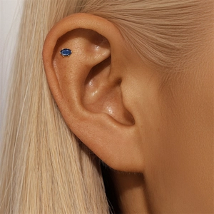 Macro detail of royal blue oval zircon stud earring on helix in S925 sterling silver