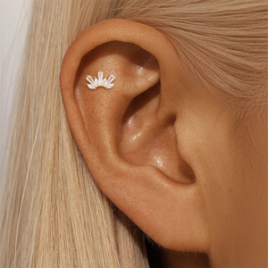 Macro detail of a gold-plated crown helix stud earring with marquise and round crystals