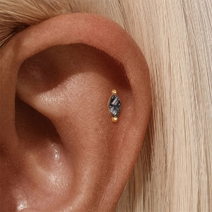 Detail of s925 silver ear stud with marquise black crystal and gold-plated floral design