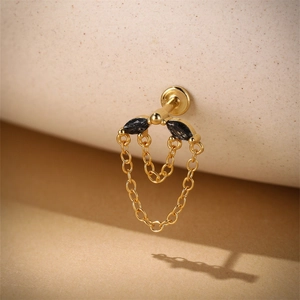 Détail du poinçon S925 sur boucle d'oreille dorée avec pierres noires et chaînes